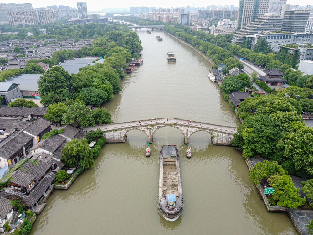 5月27日，一艘貨船駛過京杭大運河南端標志建筑杭州拱宸橋。(無人機照片)新華社記者江漢 攝