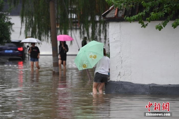 7月31日，市民行走在雨中的北京房山區(qū)瓦窯頭村。北京市氣象臺當日10時發(fā)布分區(qū)域暴雨紅色預警信號。北京市水文總站發(fā)布洪水紅色預警，預計當日12時至14時，房山區(qū)大石河流域?qū)⒊霈F(xiàn)紅色預警標準洪水。<a target='_blank' href='/'><p  align=