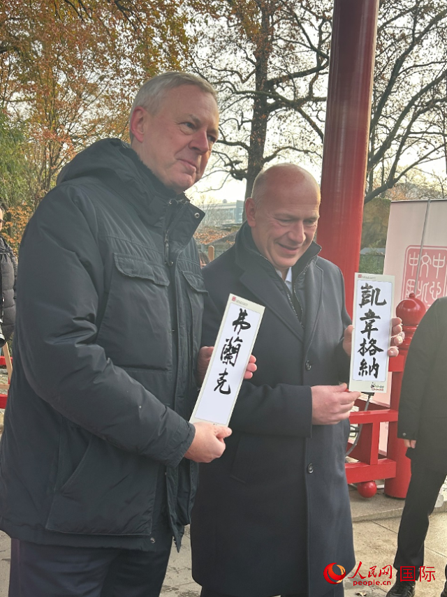 柏林市長韋格納（右）、動物園監(jiān)事會主席布魯克曼（左）手持中國文化中心工作人員現(xiàn)場手書的中文名字。人民網(wǎng)記者 徐馨攝