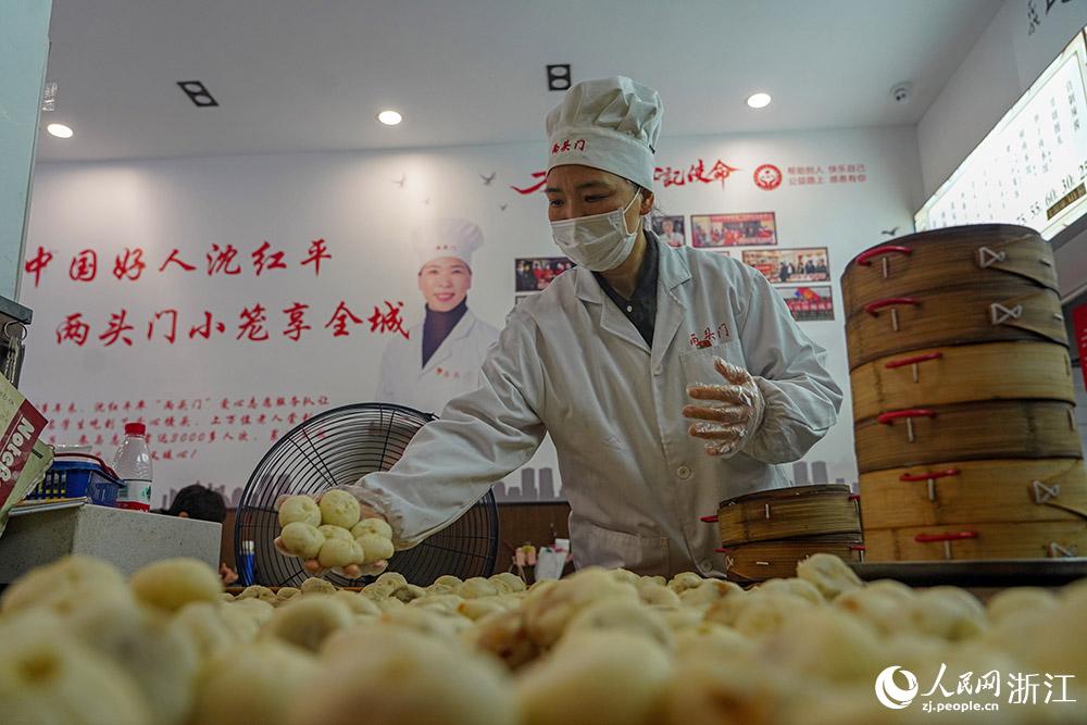 3月31日，在浙江省嵊州市甘霖鎮(zhèn)，嵊州小吃從業(yè)者沈紅平把蒸熟的小籠包晾涼，打包冷藏售賣。人民網(wǎng) 章勇濤攝