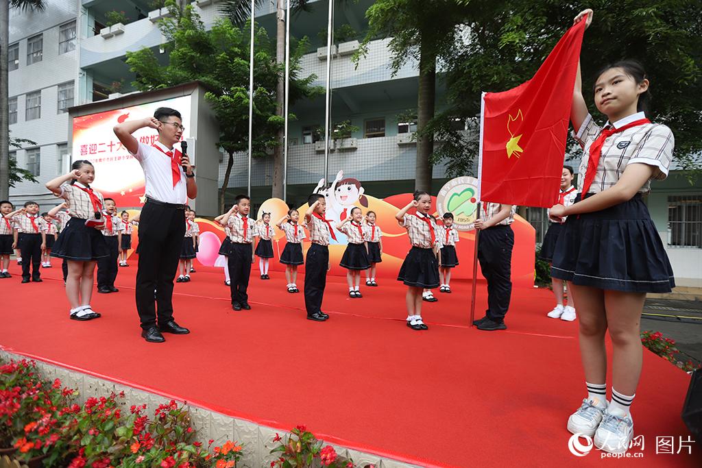 5月31日，在廣西壯族自治區(qū)南寧市民主路小學(xué)，學(xué)校大隊輔導(dǎo)員帶領(lǐng)少先隊員呼號。人民網(wǎng)記者 嚴(yán)立政攝