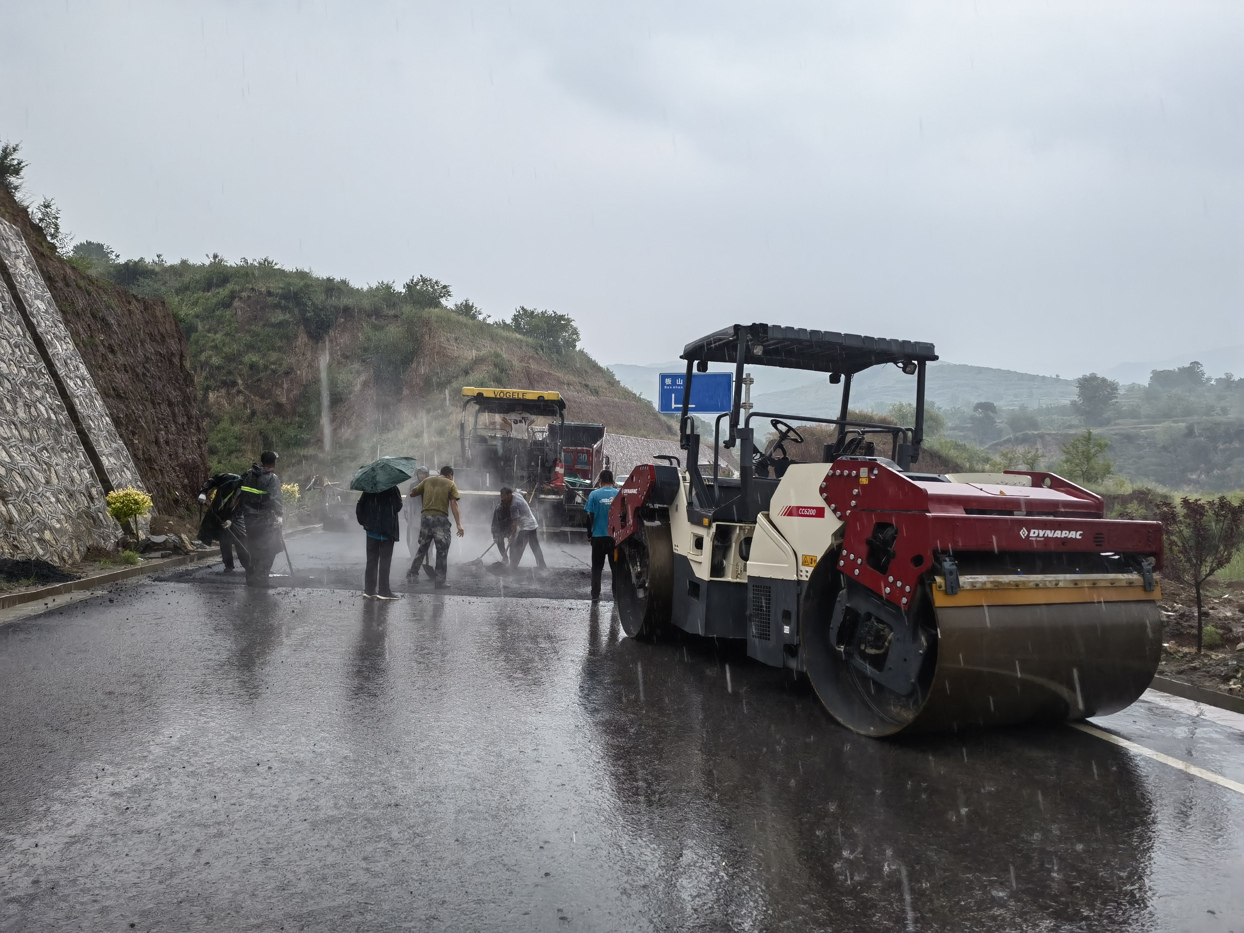 路橋工人在大雨中搶修道路。李華英 攝