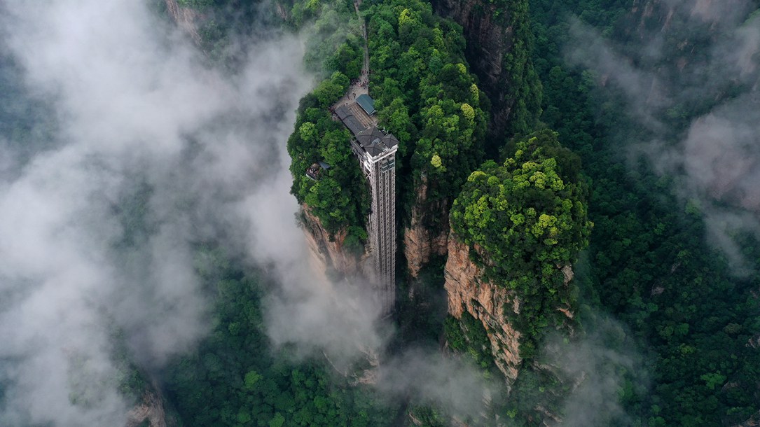 位于張家界武陵源景區(qū)的百龍?zhí)焯蓁偳对谠旗F繚繞的峰林間，雄偉壯觀。吳勇兵攝