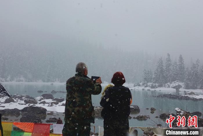 游客欣賞雪中然烏湖。　冉文娟 攝