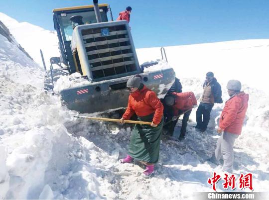 圖為普布卓瑪(左一)與養(yǎng)護工人一起抗擊雪災，搶險保通?！“⒗锏貐^(qū)公路養(yǎng)護段供圖 攝