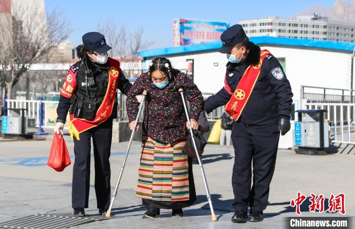 圖為拉薩鐵路公安民警幫助老人進(jìn)站乘車。　胡安鵬 攝