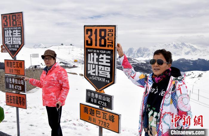 圖為5月14日，西藏林芝色季拉山觀景臺(tái)，游客與南迦巴瓦峰合影?！±盍?攝