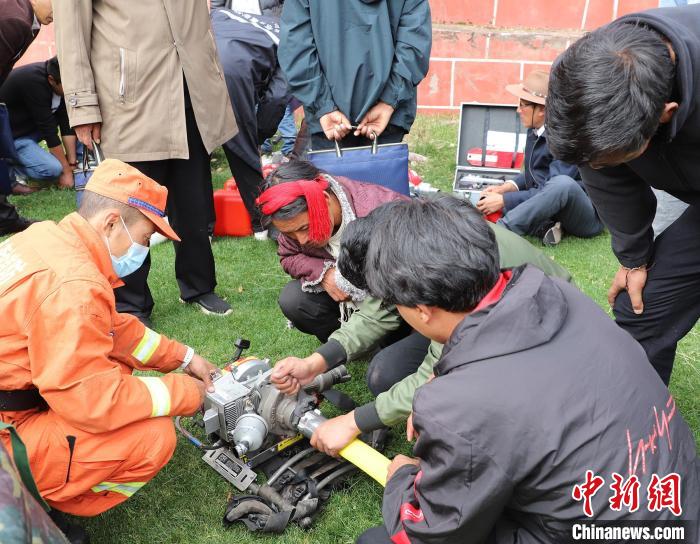 圖為森林消防員為護(hù)林員講解滅火裝備的使用方法。　昌都市森林消防支隊(duì) 供圖