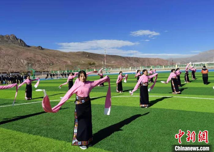 圖為青海師范大學(xué)附屬玉樹實驗學(xué)校學(xué)生在綠茵場跳起囊謙古舞—卓根瑪?！“讋?攝