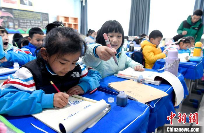 3月14日，西藏拉薩市第一小學(xué)一年級(jí)六班學(xué)生白瑪朗珍(圖左)在藏語文課上書寫藏文。　李林 攝