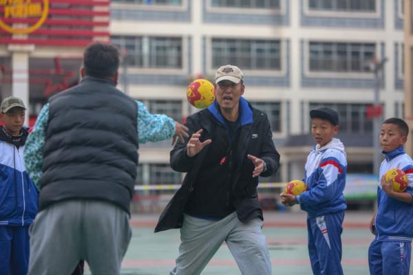 在高原上教孩子們打手球，“慢慢兒來，甭著急！”