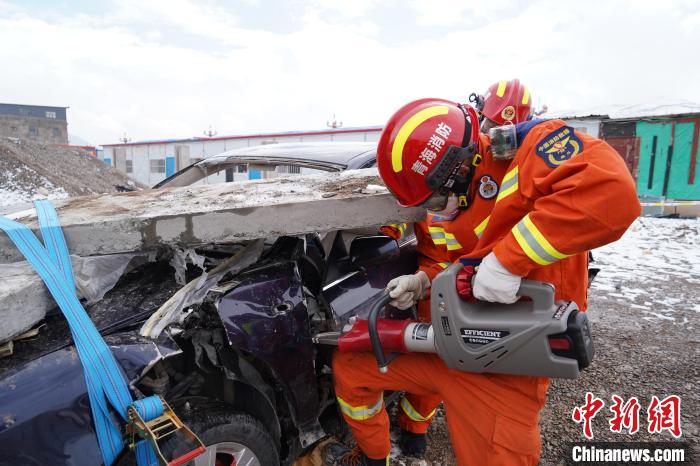 圖為地震實戰(zhàn)拉動現(xiàn)場，參演人員進(jìn)行車輛破拆。　玉樹消防供圖