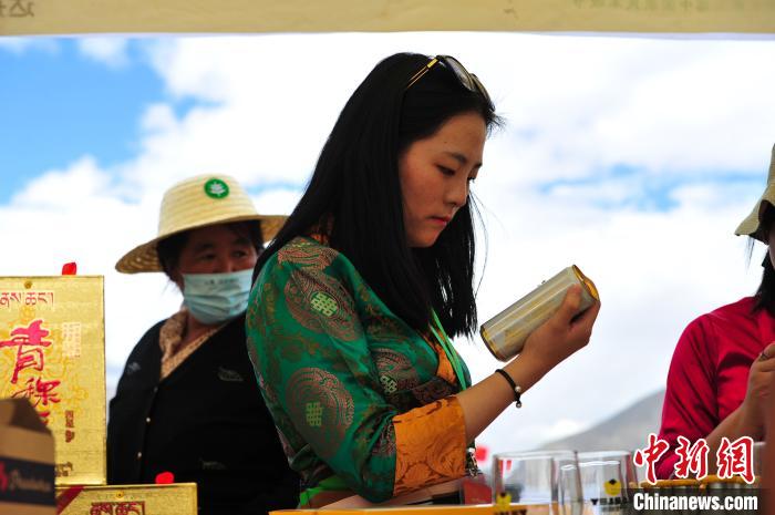 圖為拉薩市民在特色農(nóng)畜產(chǎn)品展示展銷會上選購商品?！垈?攝