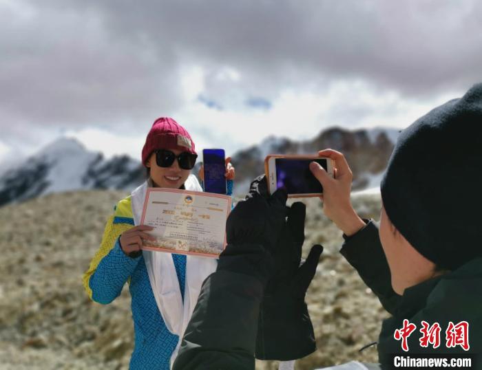 圖為5日，登頂洛堆峰的登山者獲得西藏自治區(qū)登山協(xié)會頒發(fā)的登頂證明。　張偉 攝