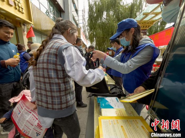 圖為志愿者為市民發(fā)放網(wǎng)絡(luò)安全宣傳手冊(cè)。　謝牧 攝