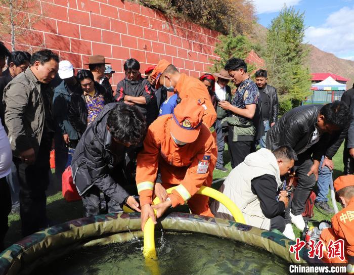 圖為森林消防員為護林員講解滅火裝備的使用方法?！〔际猩窒乐ш?供圖