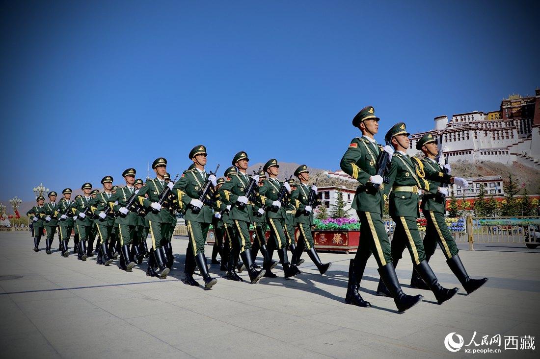 國旗護衛(wèi)隊隊員緊握鋼槍，踏著威武雄壯的步伐，走向國旗臺。人民網(wǎng) 次仁羅布攝