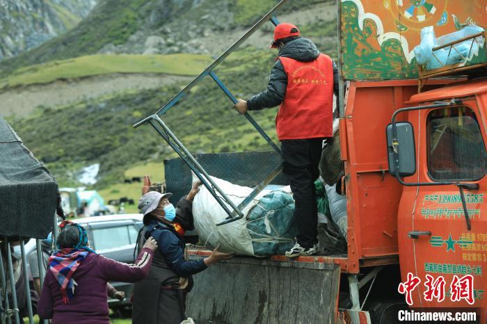 圖為工作人員幫助牧民們卸家具?！÷蹇?攝