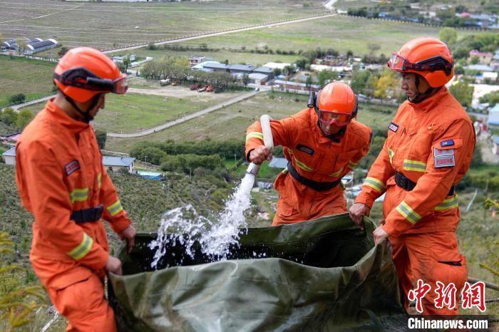 技能大練兵過程中，消防員在陡坡上向蓄水池注水?！±顕鵂c 攝