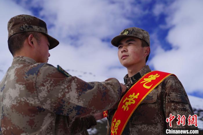 排長王朝偉(圖左)給退伍老兵佩戴大紅花?！∥鞑厣侥宪姺謪^(qū)某團(tuán)供圖