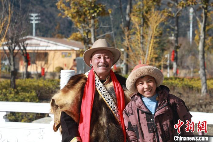 圖為林芝市巴宜區(qū)布久鄉(xiāng)仲果村村民桑杰與孫子一起參加藏歷新年活動?！埩?攝