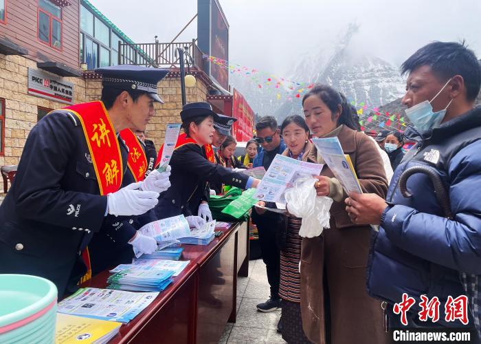 圖為山南玉麥邊境派出所民警為轄區(qū)群眾發(fā)放法律知識宣傳單?！＄婗?　攝